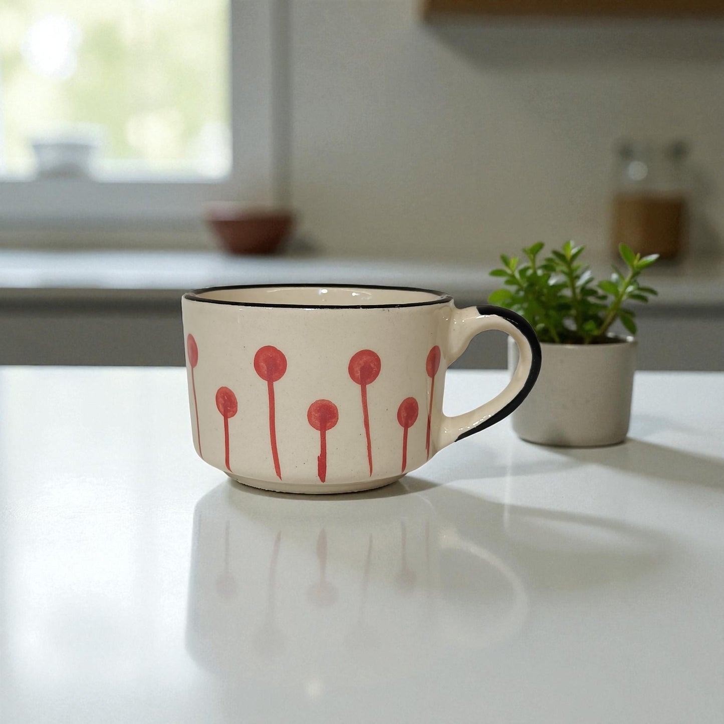 Ceramic mug with red floral design on a kitchen counter