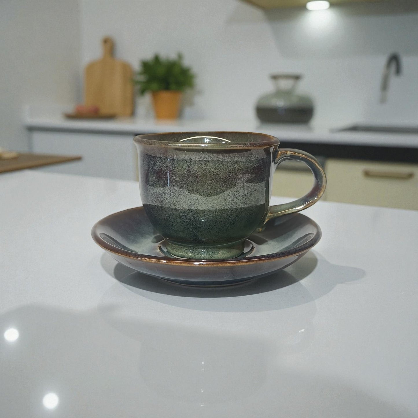 Ceramic cup and saucer on a kitchen counter with a blurred background