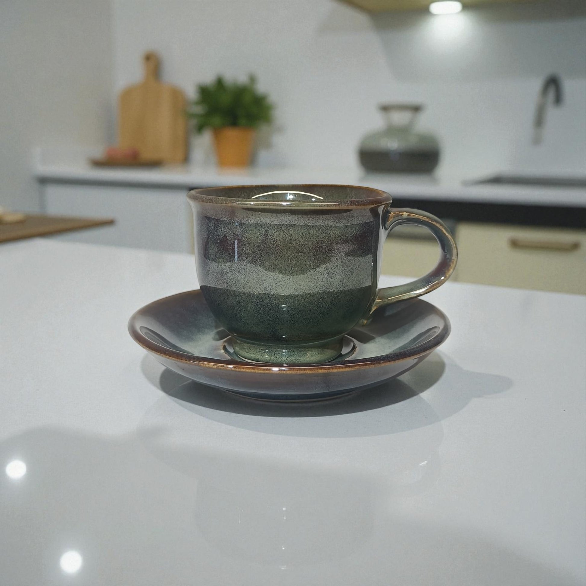 Ceramic cup and saucer on a kitchen counter with a blurred background