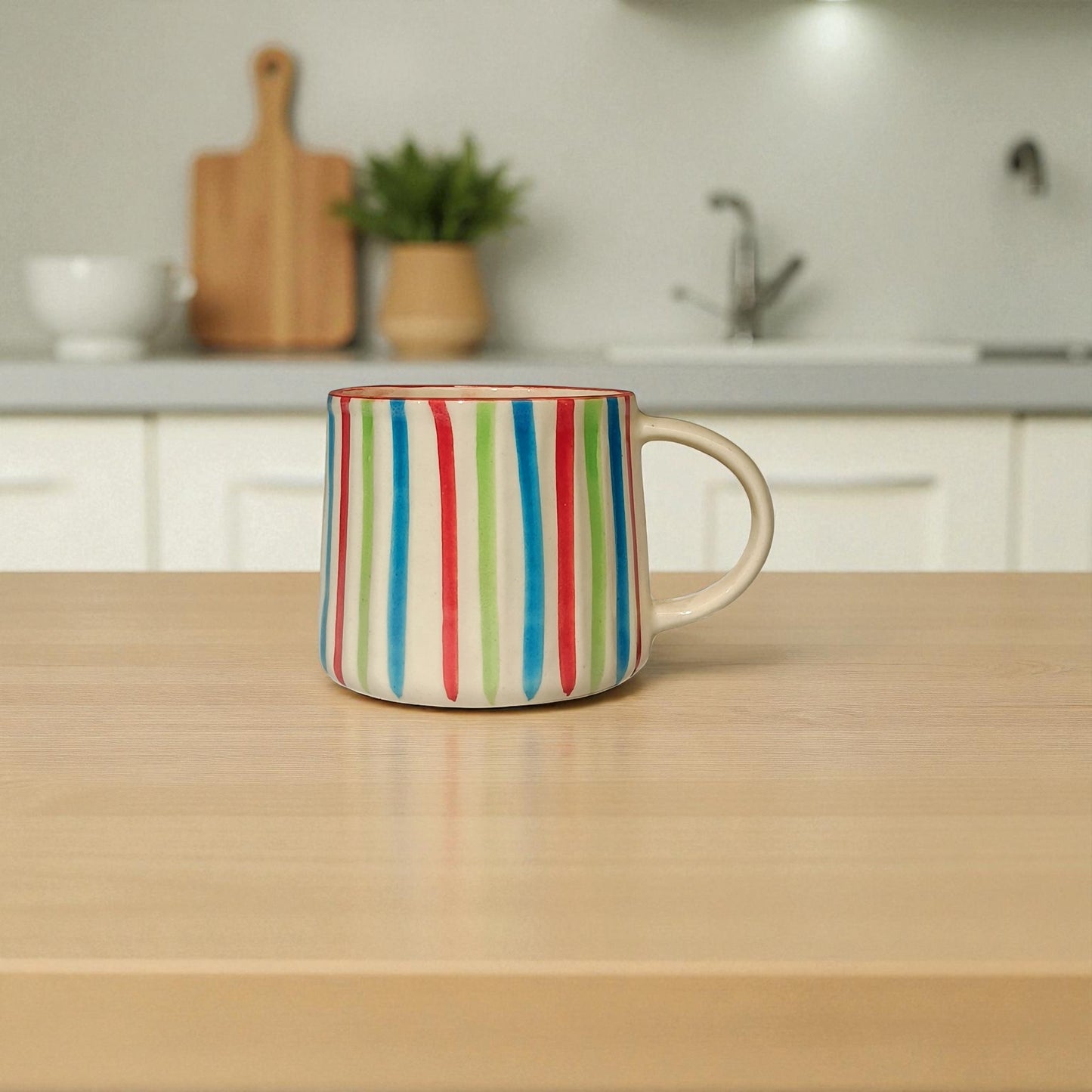 Colorful striped mug on a wooden table with a kitchen background