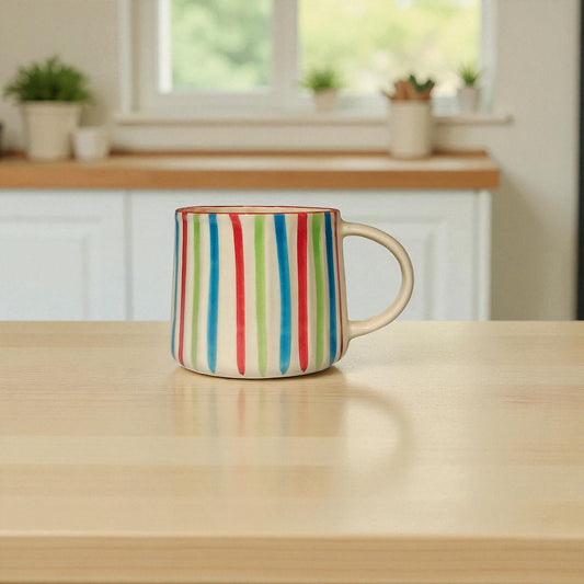 Colorful striped mug on a wooden table with a kitchen background