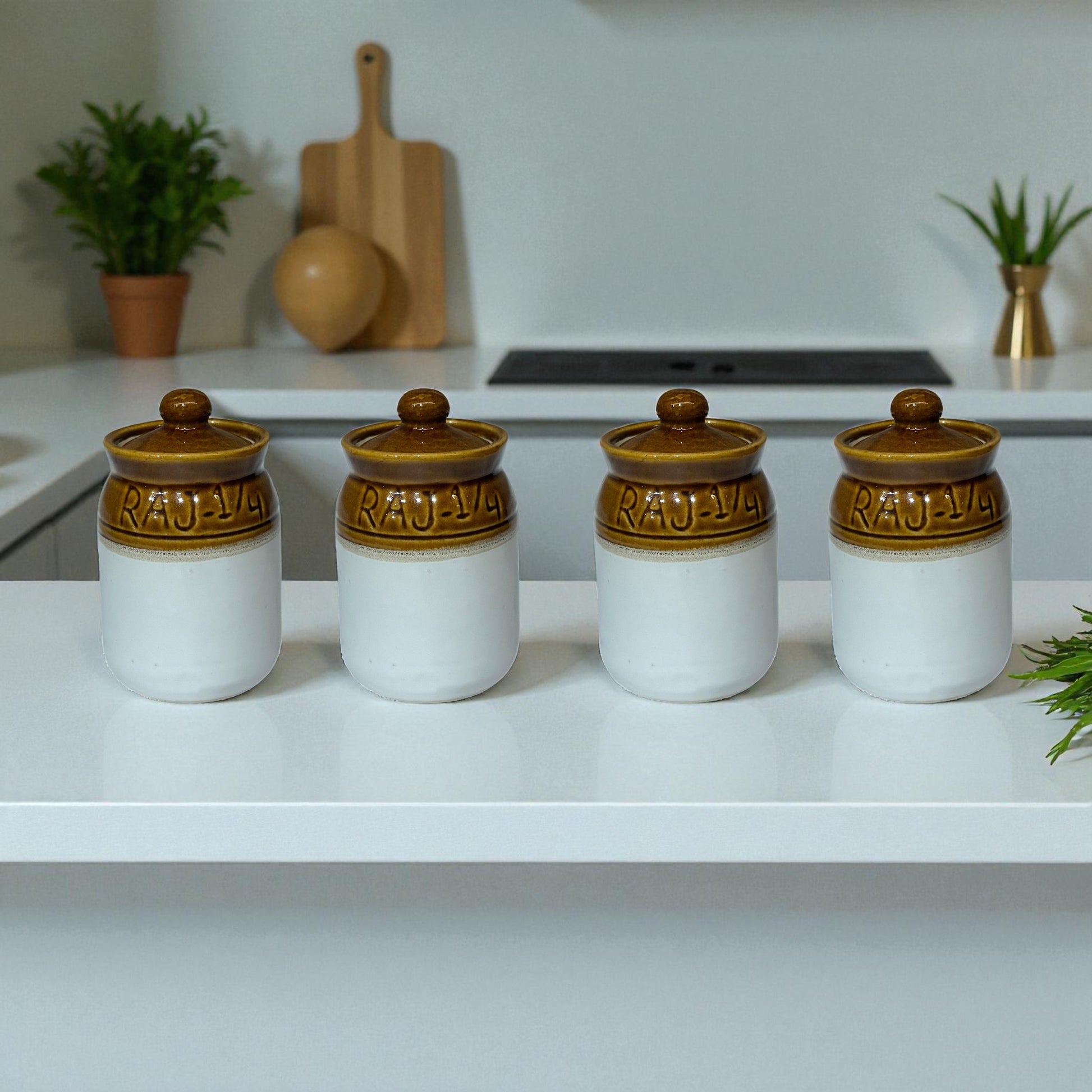 Four white jars with brown lids on a kitchen counter