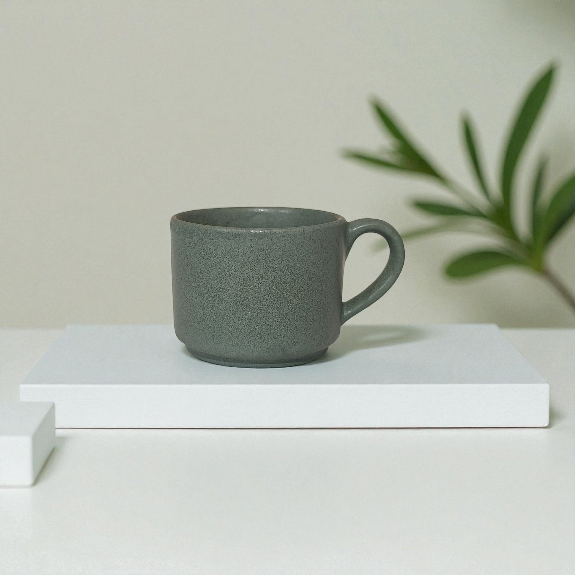 Gray mug on a white surface with a minimal background