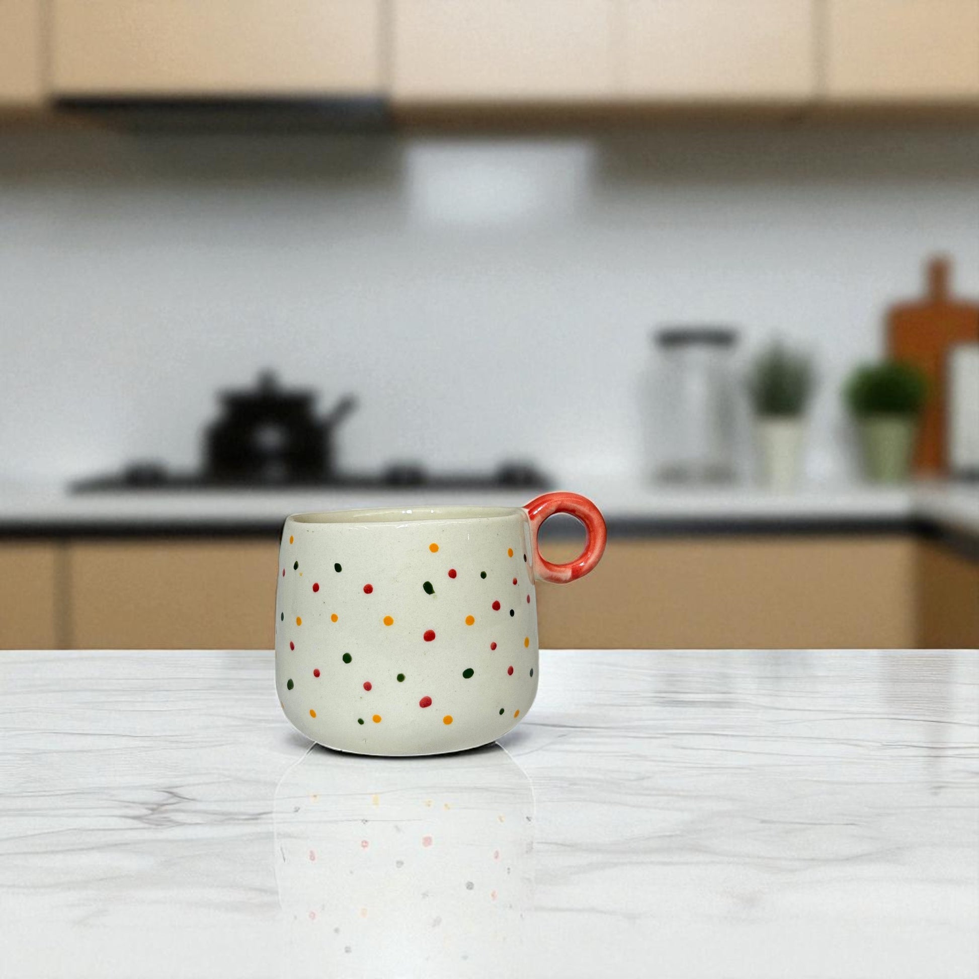 Polka dot mug with a red handle on a kitchen counter