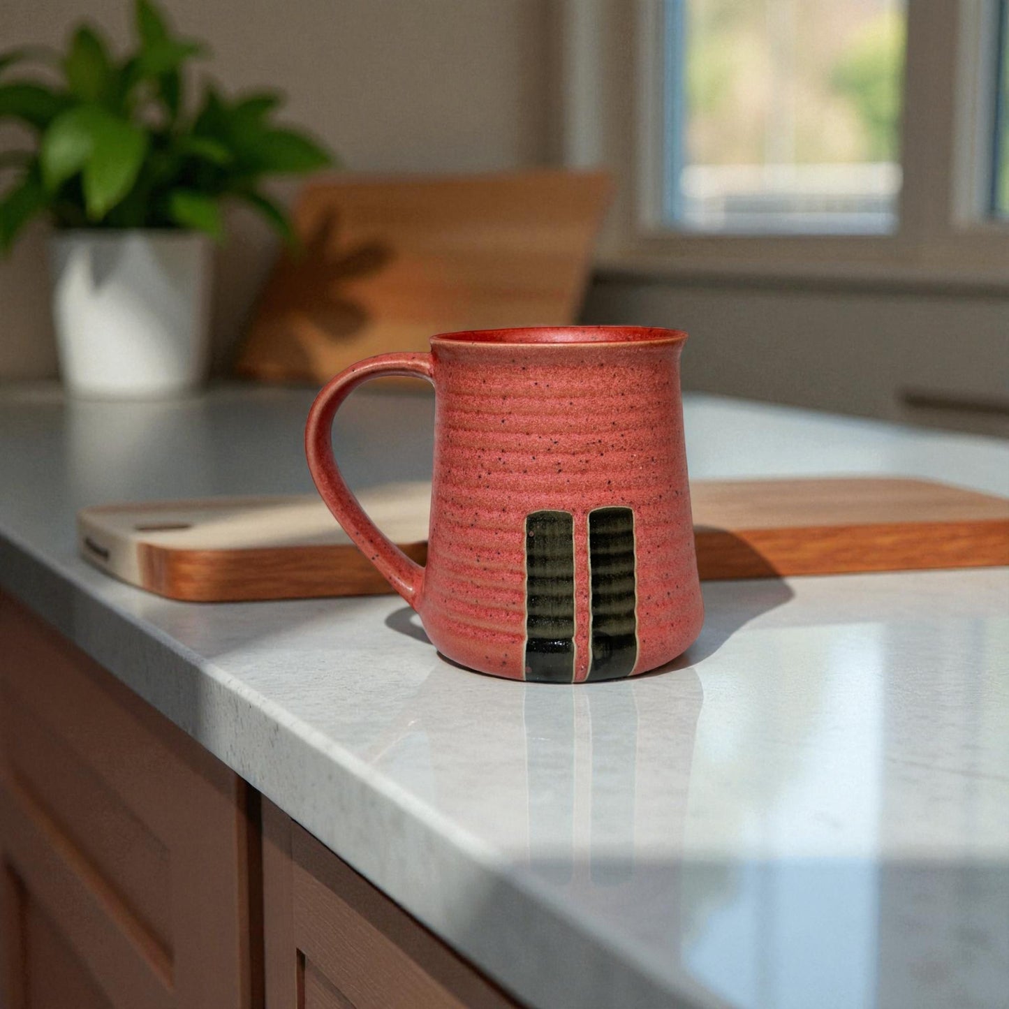 Red ceramic mug on a kitchen counter with a blurred background