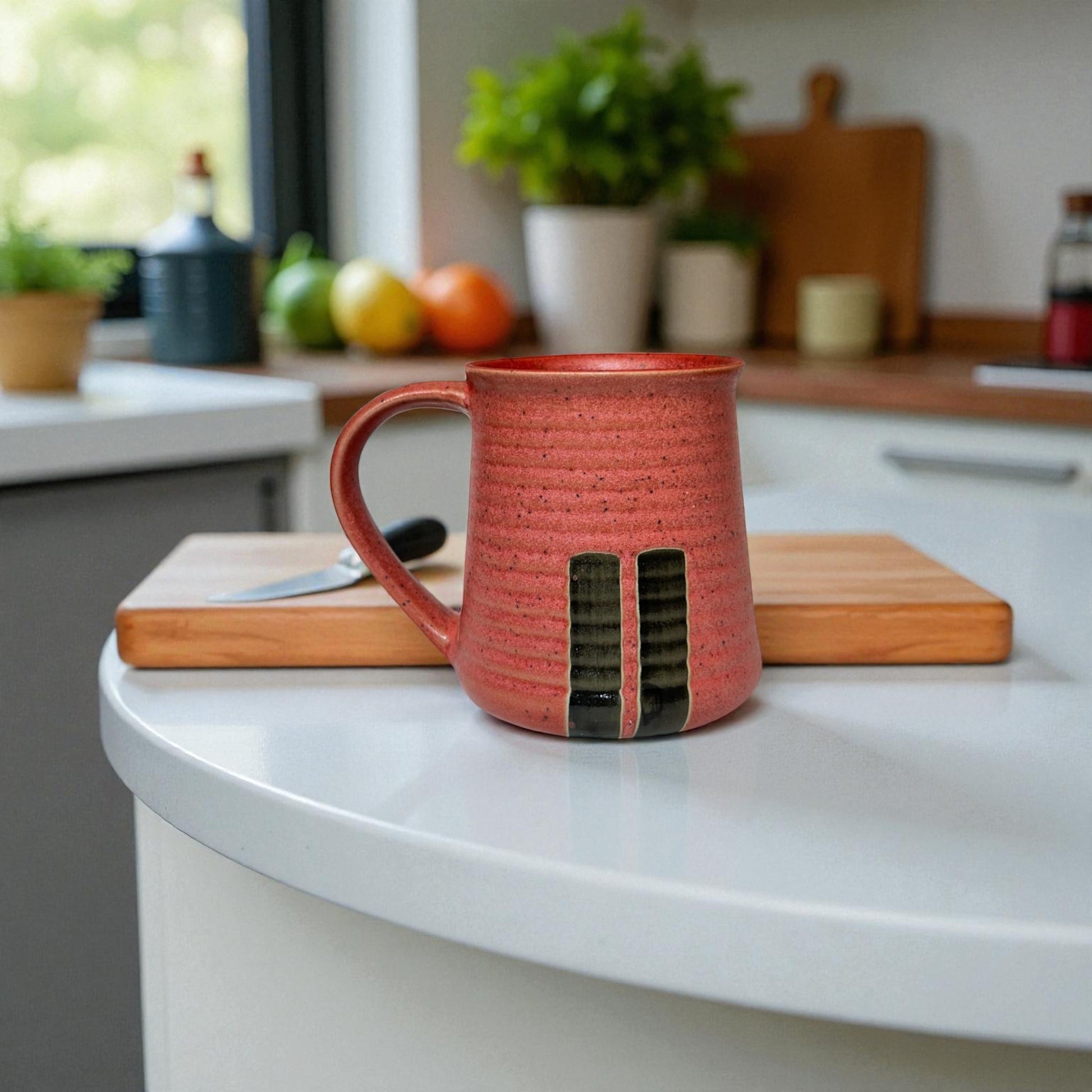 Red ceramic mug with a unique design on a kitchen counter